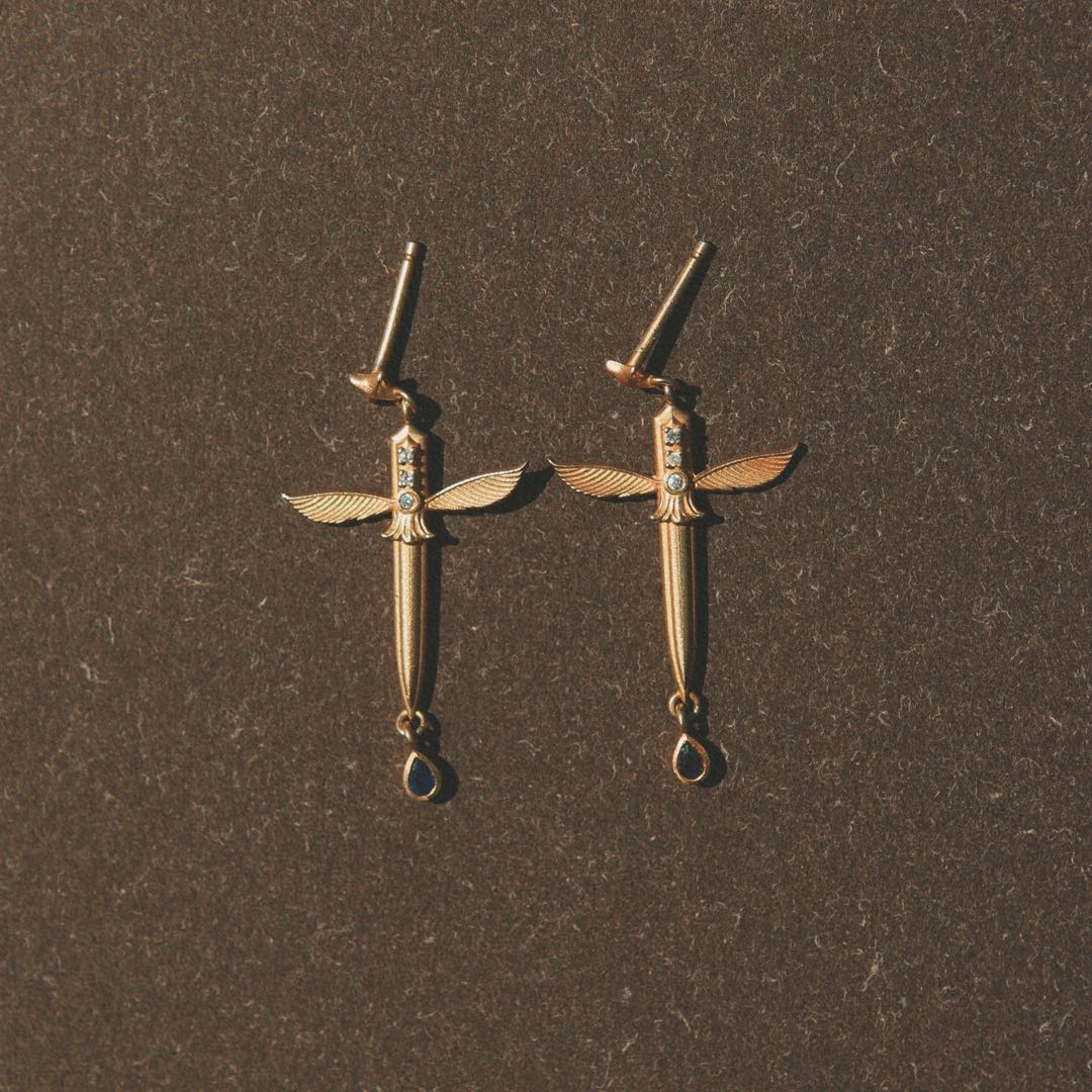 Yiru.jewellery Queen of Swords earrings featuring intricate silver sword and crown design with gemstone accents