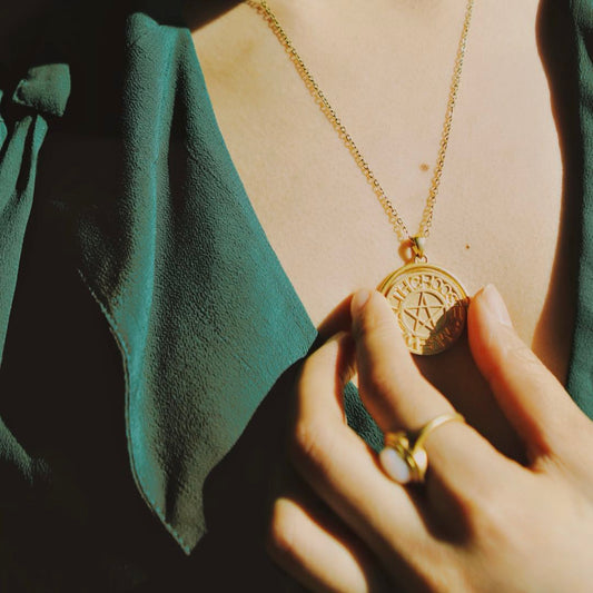 Yiru.jewellery pentacle signet pendant featuring a detailed metal pentacle design on a chain, close-up view.
