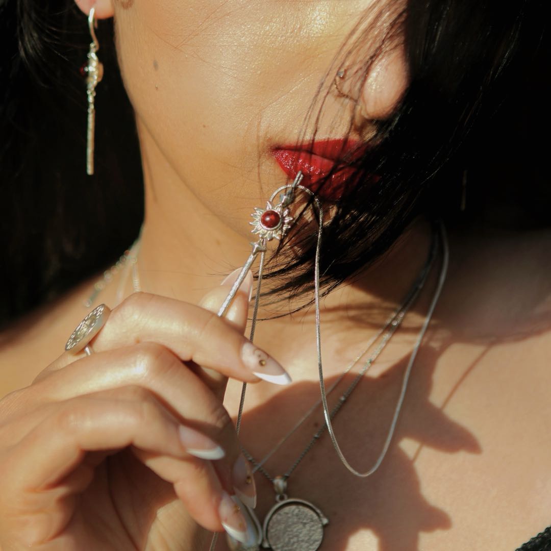 Yiru.jewellery Queen of Wands pendant featuring detailed gold-toned design with gemstone accents on a chain.